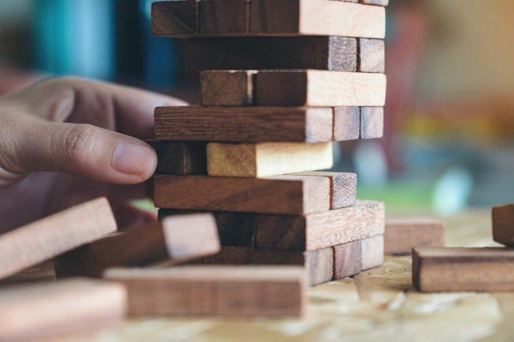 Closeup image of a hand holding and playing Tumble tower wooden block game