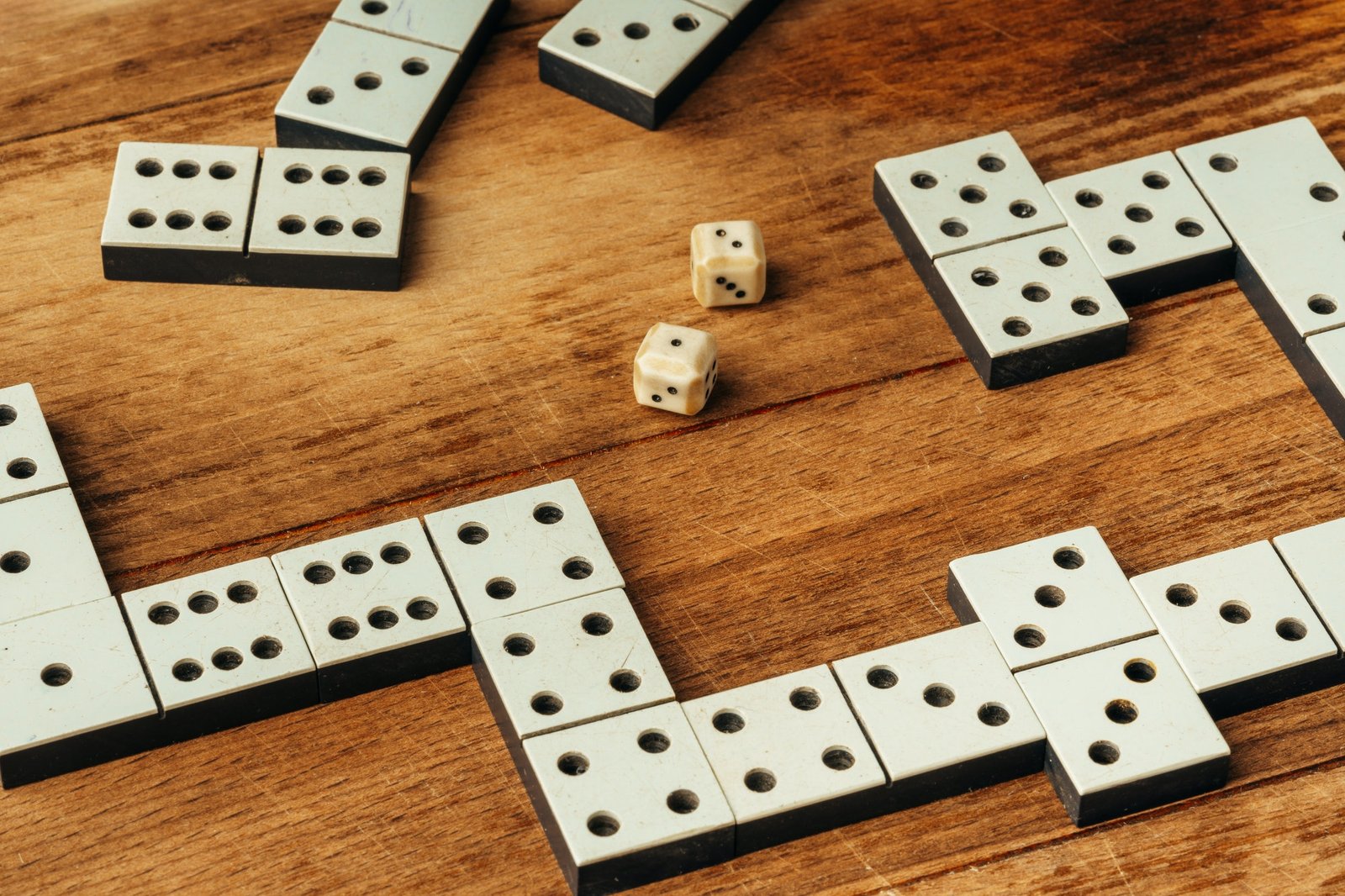 Domino game on brown wooden background close up